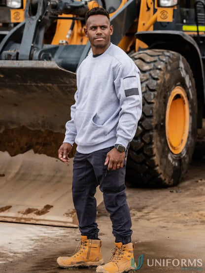 Men’s grey work fleece crew neck jumper with pockets, paired with dark work pants and tan boots