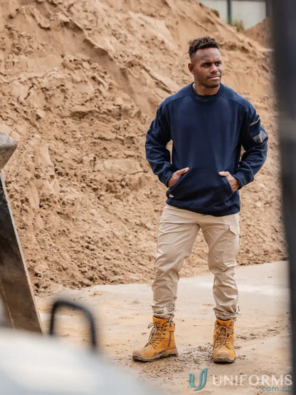 Man wearing navy work fleece crew neck jumper with tan work pants and boots