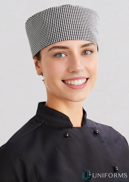 Smiling woman in chef’s uniform wearing Yes Chef Flat Top Cap from Biz Collection Chef