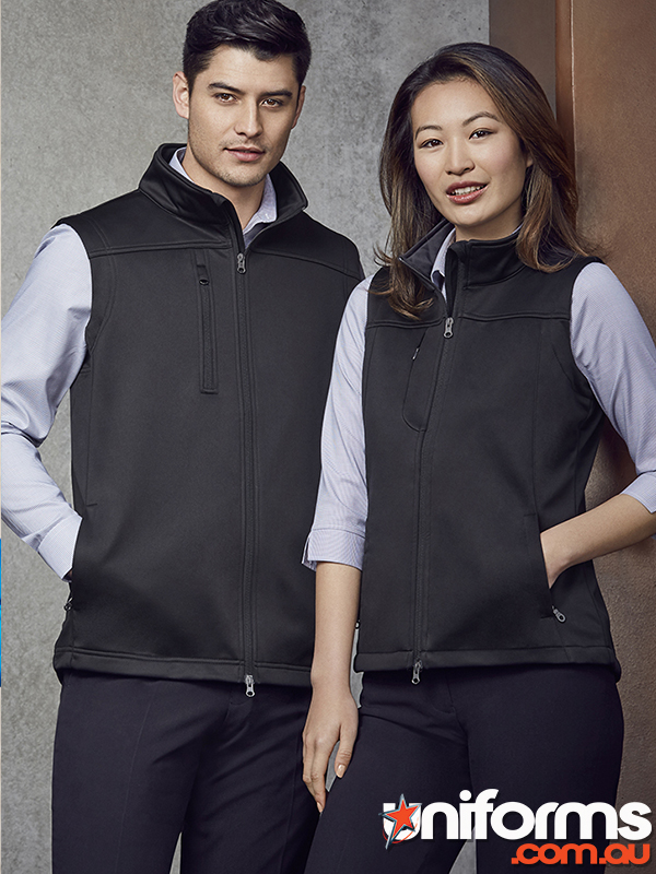Two people wearing black jackets and pants stand together, highlighting the Biz Collection Women's Softshell Vest J29123.