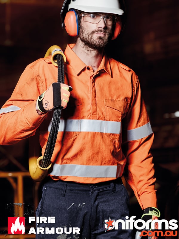 A man wearing Syzmic FR Closed Front Hooped Taped Shirt ZW134 holding a roll of cable on his shoulder.