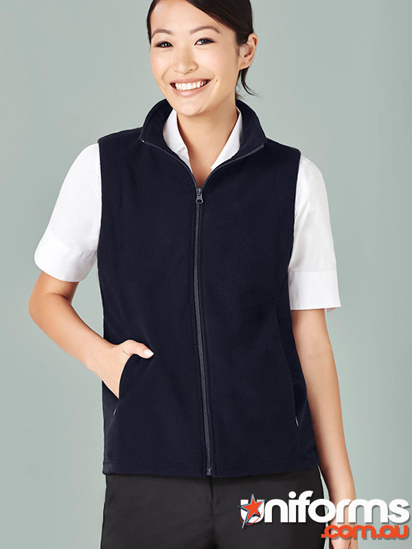 A woman in a navy vest and black pants, showcasing the Biz Collection Womens Plain Vest PF905 in a stylish setting.