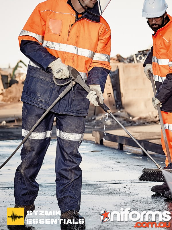 Two men using a pressure washer to clean concrete wearing the ZJ352 Taped Storm Pant.