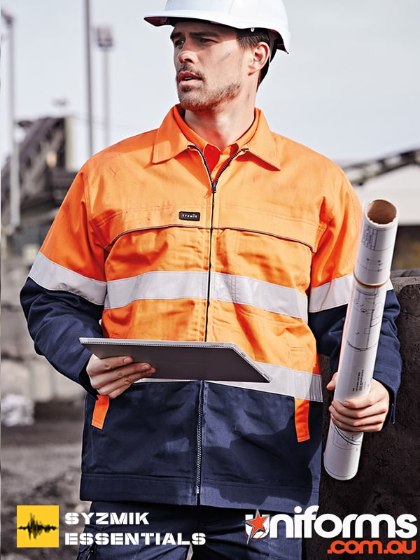 A man holding building plans wearing the Syzmic Men's Hi Vis Cotton Drill Jacket ZJ590.