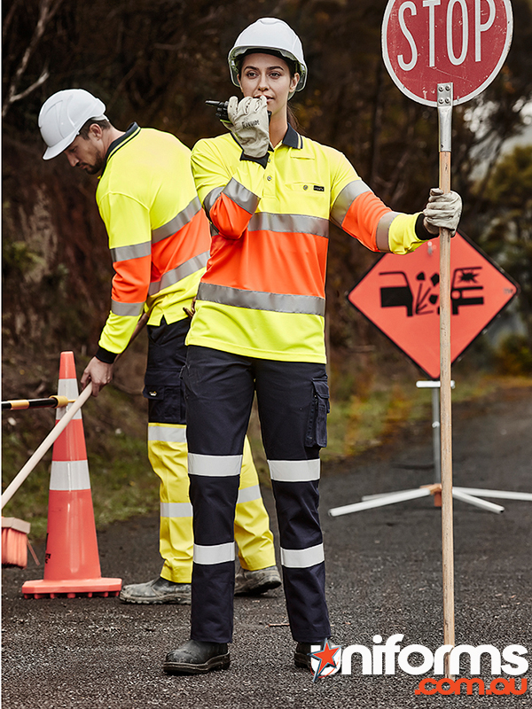 A lady traffic ontroller wearing the Syzmic Womens Bio Motion Pant style ZP720 holds a stop sign.