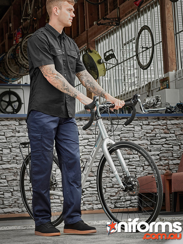 A man stands next to a bike, dressed in Syzmic Men's Midweight Drill Cargo Pants style ZW001.